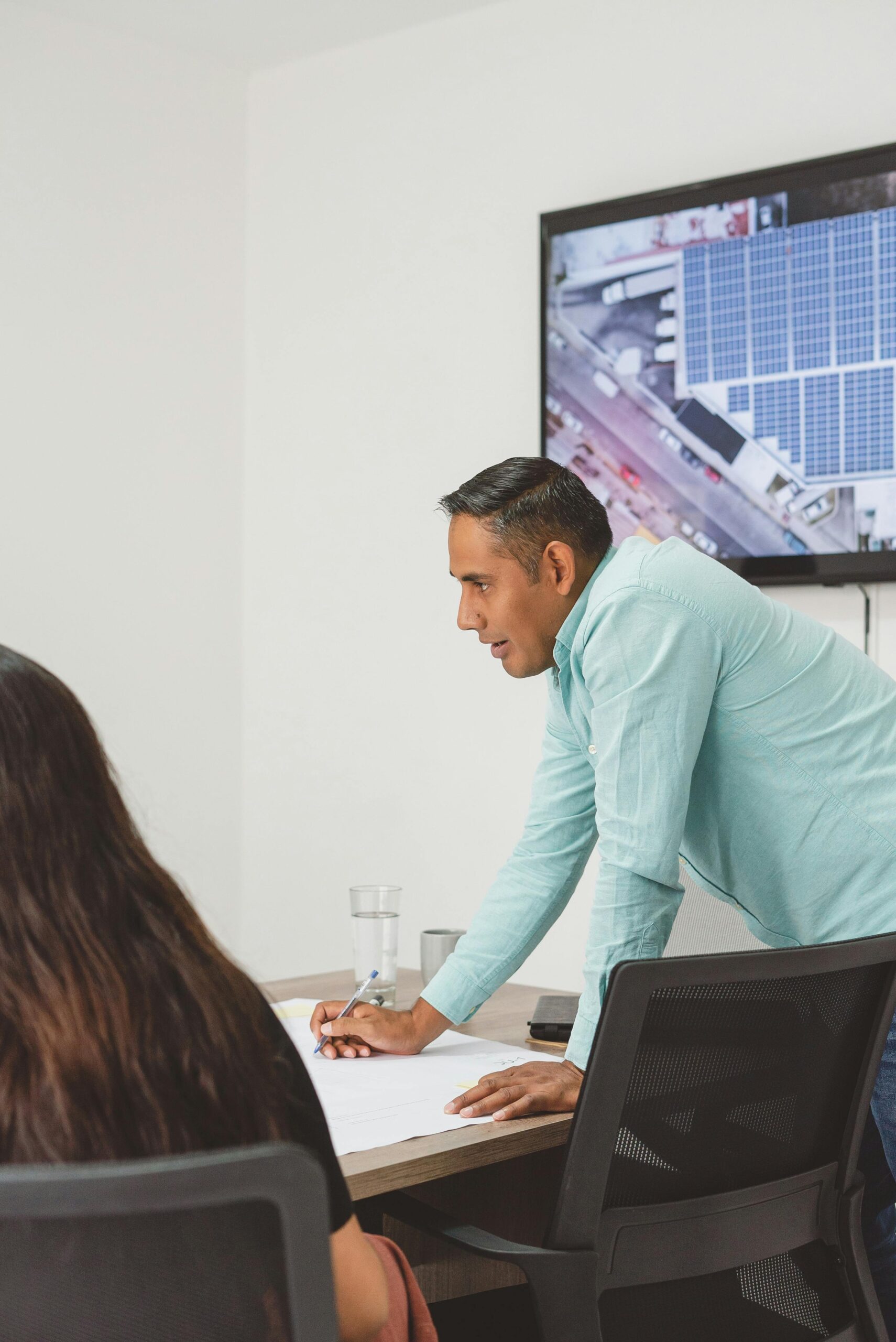 Two professionals in an office setting discuss a solar panel project, fostering business collaboration.